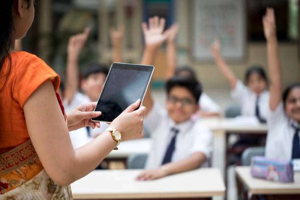 Teacher using tablet computer in elementary school lesson